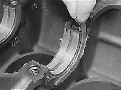 Removal the upper thrust half rings from the engine cylinder block