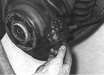 Removal the spring from the caliper that presses the brake pads