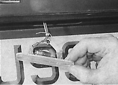 Removal the bulb from the spring contacts of the license plate light