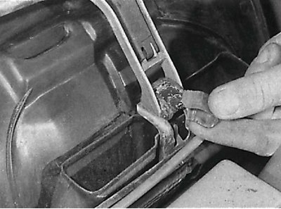 Releasing the retaining clip located at the base of the windshield wiper motor