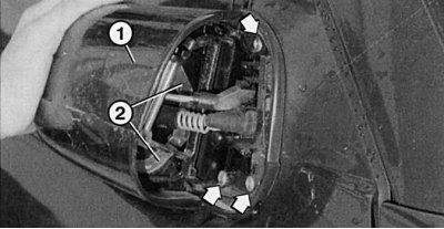 Fig. 10.11. To access the spring clip (2) for fastening the housing (1), fold the mirror back. The…