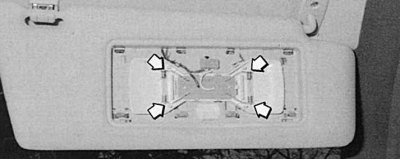 Fig. 10.20. Spotlights in sun visors are installed in spring contacts (arrows)