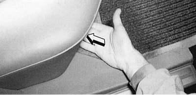 Fig. 10.28. To remove the rear seat cushion, press the slightly recessed inward latches (arrow) on…