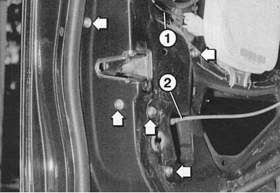 Fig. 11.32. Door lock mounting bolts (arrows): 1 – door lock opening lever drive; 2 – vacuum hose…