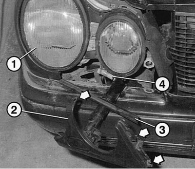 Fig. 9.21. After unscrewing the mounting bolts (arrows), the protective panel 2 of the headlight 1…