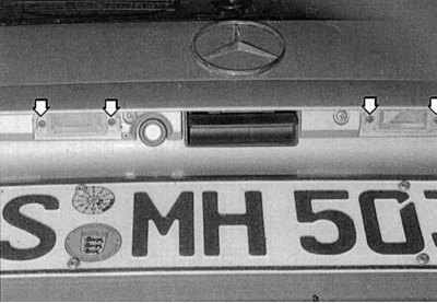 Fig. 9.29. On the T-model, each light is secured with two bolts (arrows) to the rear door housing